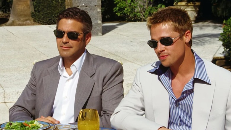Danny și Rusty zâmbesc în timp ce își plănuiesc lovitura emblematică în Ocean's Eleven