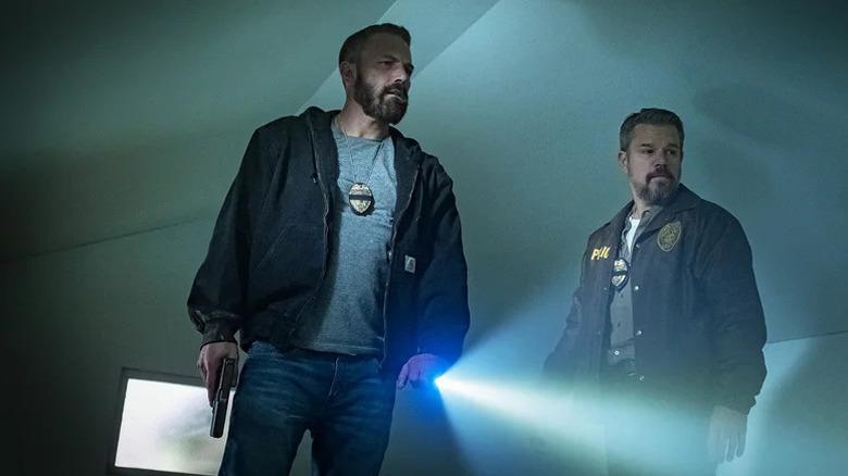 Sergentul detectiv al lui Ben Affleck, JD Byrne, luminează o lanternă în timp ce locotenentul lui Matt Damon, Dane Dumars, urmărește filmul The Rip