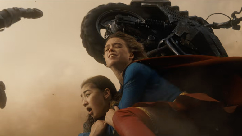 Milly Alcock în rolul Kara Zor-El o protejează pe Eve Ridley în rolul Ruthye Marye Knoll în Supergirl (2026)