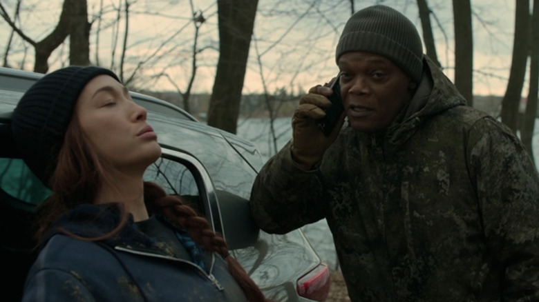 Anna Dutton din Maggie Q se sprijină pe o mașină în timp ce Moody Dutton din Samuel L. Jackson vorbește la telefonul mobil în The Protégé