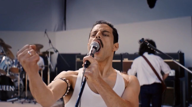 Rami Malek în rolul lui Freddie Mercury cântând pe scenă în Bohemian Rhapsody