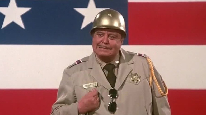 Jackie Gleason în rolul șeriful Buford T. Justice în fața unui steag în Smokey and the Bandit Part 3