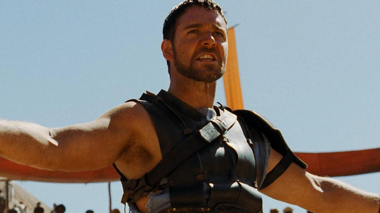 Maximus (Russell Crowe) își întinde brațele într-o arenă 