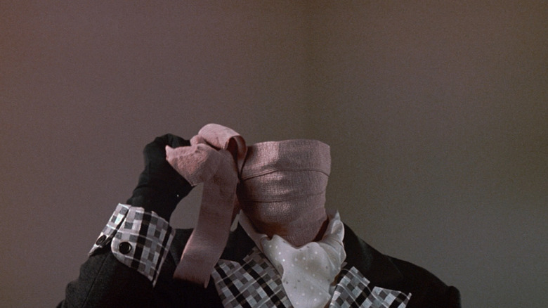Chevy Chase în timp ce Nick Halloway își desfășoară bandaje în jurul feței în Memoirs of an Invisible Man