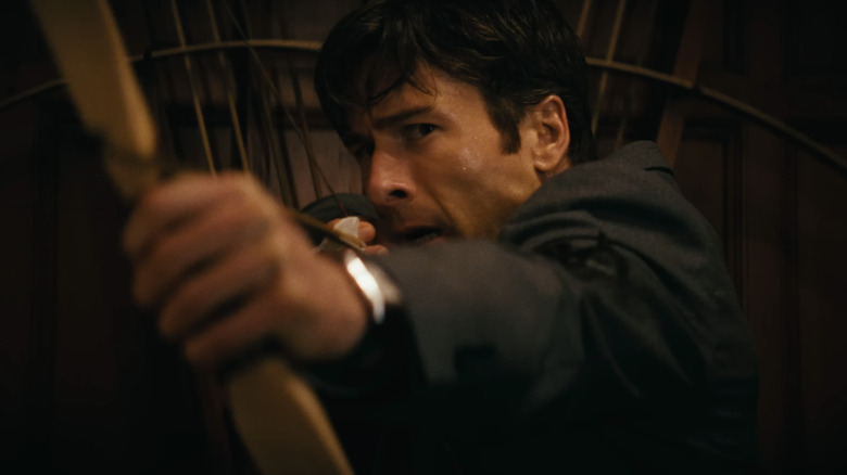 Becket Redfellow al lui Glen Powell țintește un arc și săgeți în prim-plan în Cum să faci o ucidere