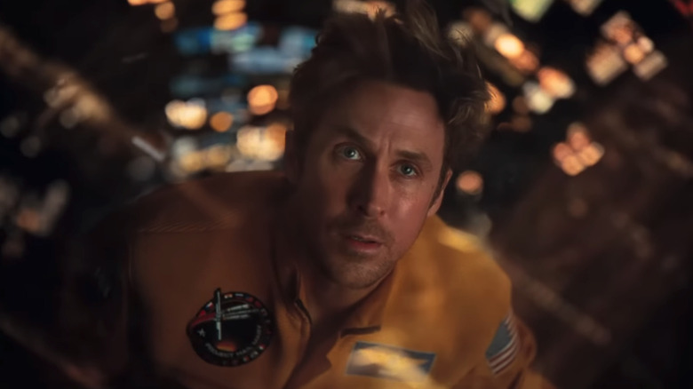 Ryland Grace al lui Ryan Gosling este văzut în prim-plan în timp ce plutește în mijlocul unei mări de lumini în Project Hail Mary