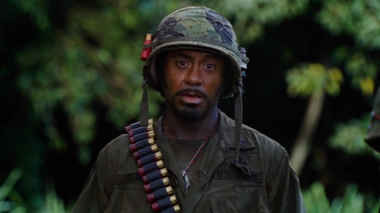 Robert Downey Jr. în rolul lui Kirk Lazarus mergând prin junglă în Tropic Thunder