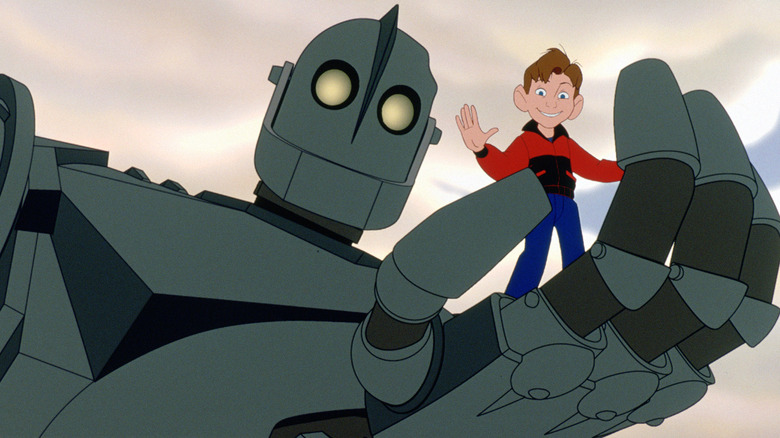 Vin Diesel ca vocea lui The Iron Giant, ținându-l sus pe Eli Marienthal ca vocea lui Hogarth în palma lui în The Iron Giant