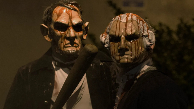 Oameni care poartă măști înfricoșătoare ale lui Abraham Lincoln și George Washington în The Purge: Election Year