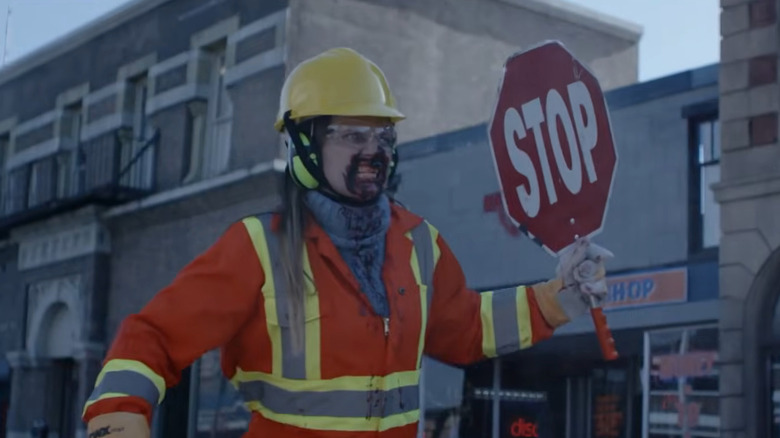 Un zombi care ține un semn de oprire în Dead Rising: Watchtower
