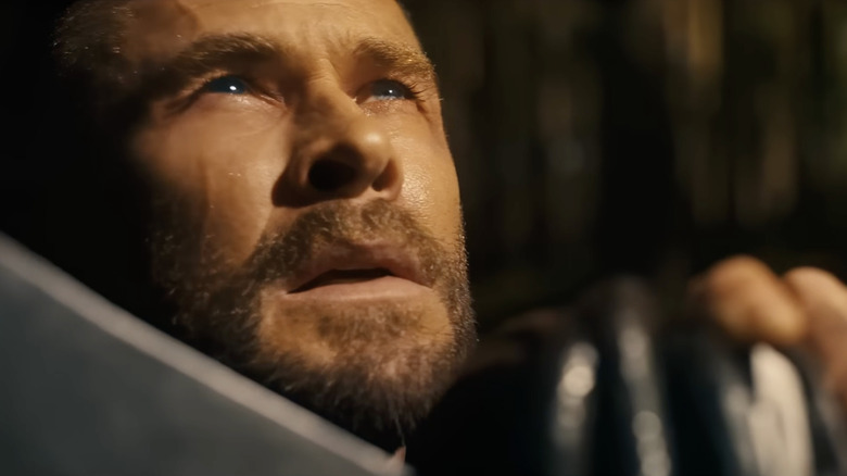 Chris Hemsworth în rolul lui Thor ținându-și toporul de luptă în fața feței și privind în sus în Avengers: Doomsday