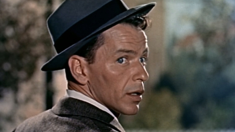 Barney Sloan de la Frank Sinatra se uită peste umăr în timp ce stă pe o verandă în Young at Heart