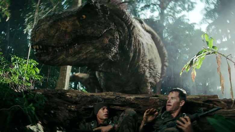Baker și Leon se ascund în spatele unui buștean de la un T-rex în Primitive War
