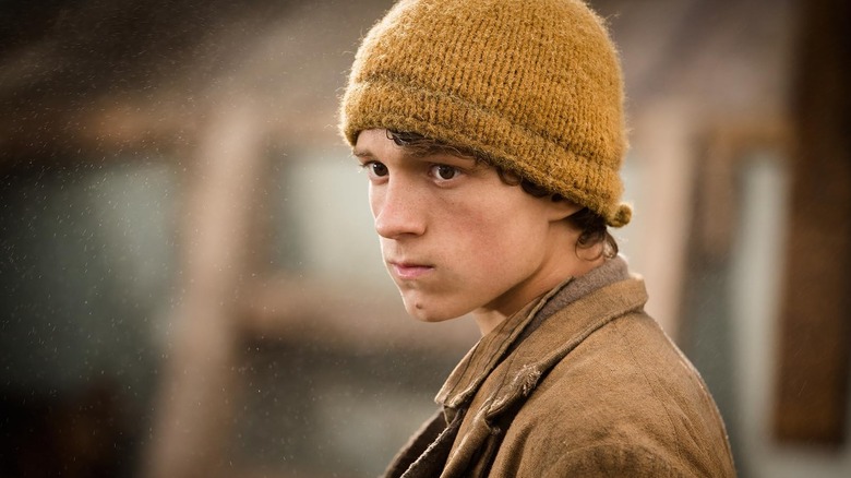 Tom Hiddleston în rolul lui Thomas Nickerson purtând o șapcă galbenă în In the Heart of the Sea