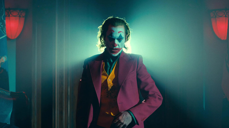Joaquin Phoenix în rolul lui Arthur Fleck în costum cu sânge pe vestă în Joker: Folie a Deux