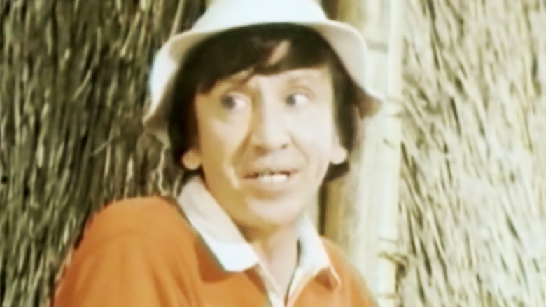 Gilliganul lui Bob Denver se uită peste cadru în timp ce stă lângă o colibă ​​în Rescue from Gilligan's Island