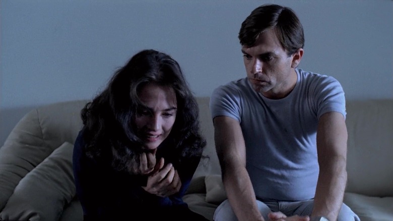 Sam Neill, în rolul lui Mark, stă pe canapea cu Isabelle Adjani ca Anna în Possession