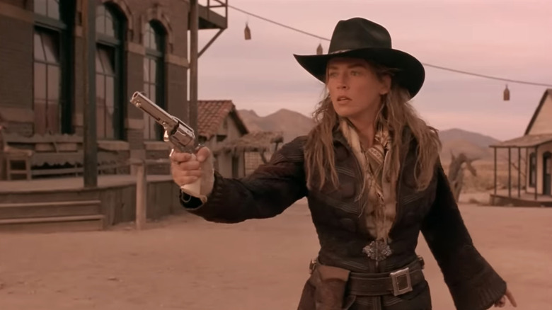 Ellen a lui Sharon Stone "Doamna" McKenzie ține pistolul pe o stradă a orașului de frontieră din The Quick and the Dead