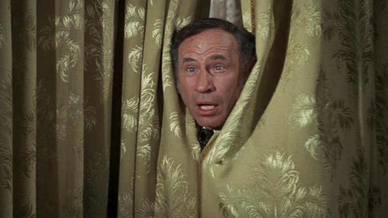 Mel Brooks se uită de pe o cortină în rolul guvernatorului William J. Le Petomane în Blazing Saddles