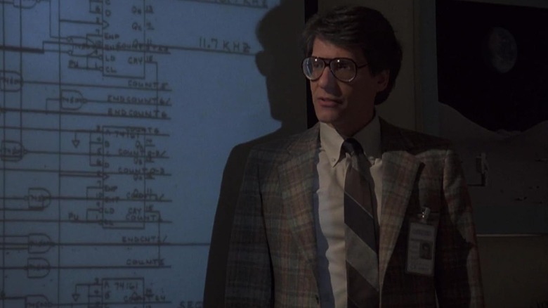 David Cronenberg ca supraveghetor de grup în fața unei imagini proiectate în Into the Night
