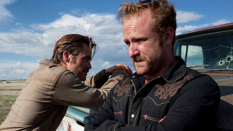 Chris Pine în rolul lui Toby și Ben Foster în rolul lui Tanner, sprijinit de un camion în Hell sau High Water