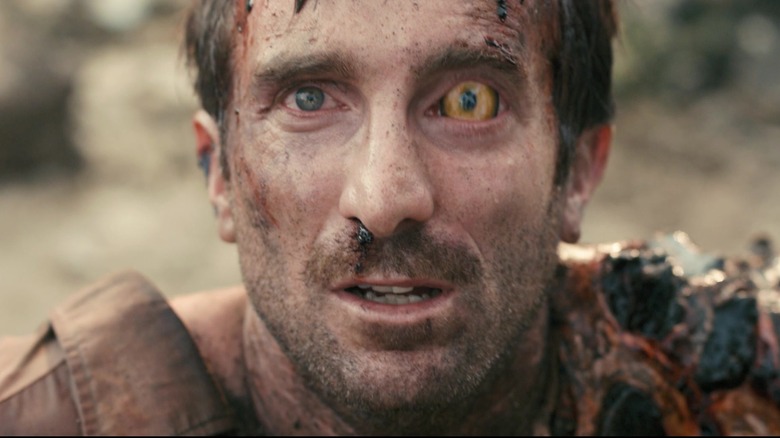 Sharlto Copley ca Wikus van de Merwe privind în sus (transformat parțial într-un extraterestru) în Districtul 9