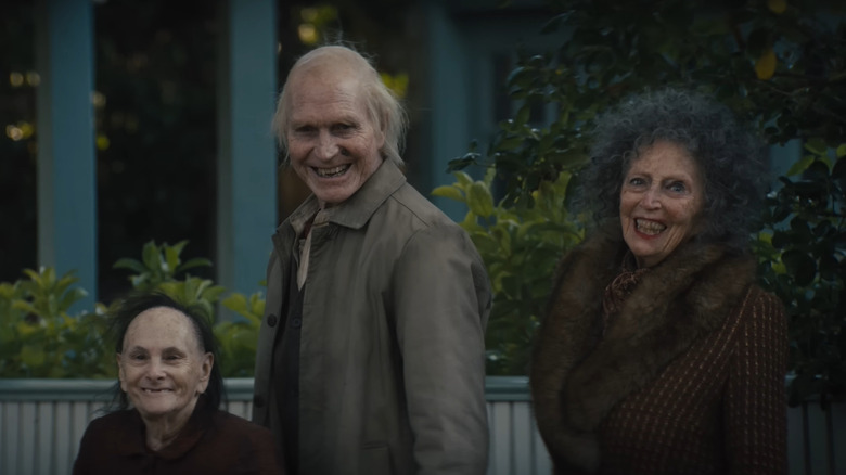 Trei demoni bătrâni stând pe stradă zâmbind în Insidious: Out of the Further