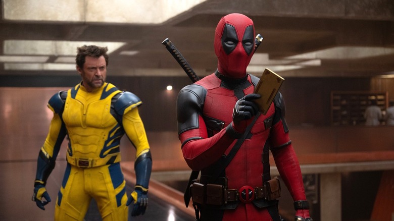 Ryan Reynolds ca Deadpool în TVA cu Hugh Jackman ca Wolverine în spatele lui în Deadpool & Wolverine