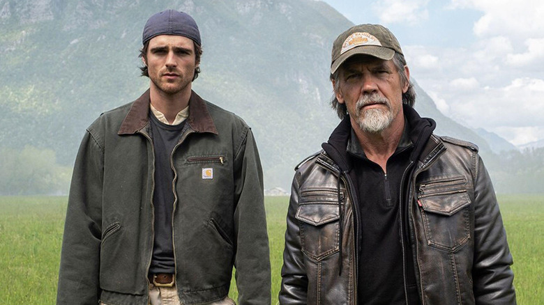 Jacob Elordi ca Hig stând lângă Josh Brolin ca Bangley într-un câmp din The Dog Stars