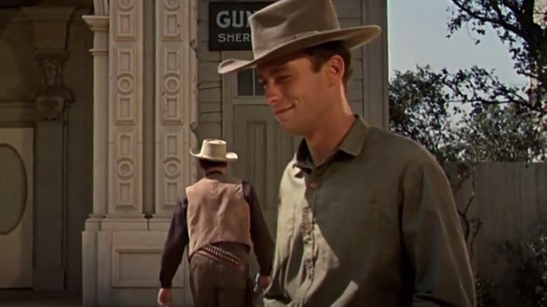 Tom the ranch, al lui Clint Eastwood, zâmbește în timp ce se îndepărtează de șeriful lui John Agar, Bill Jorden, în Star in the Dust
