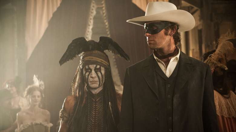 Johnny Depp în rolul lui Tonto și Armie Hammer în rolul Rangerului singuratic într-un salon în The Lone Ranger (2013)
