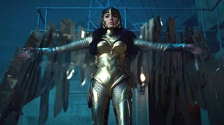 Gal Gadot ca Wonder Woman în costumul ei auriu cu brațele întinse în Wonder Woman 1984