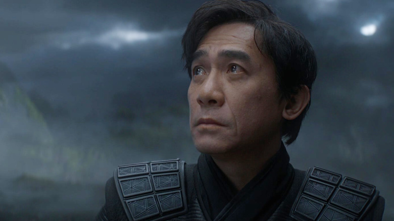 Tony Leung în rolul lui Xu Wenwu privind în sus la un cer furtunos din Shang-Chi și Legenda celor zece inele