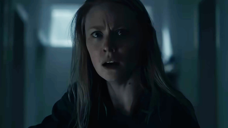 Deborah Ann Woll în rolul lui Meg, care arată alarmată pe un hol întunecat din The Cycle