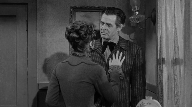 Helen Crane din Tina Louise își pune mâna pe pieptul lui Blaise Starrett de Robert Ryan în Ziua haiducului