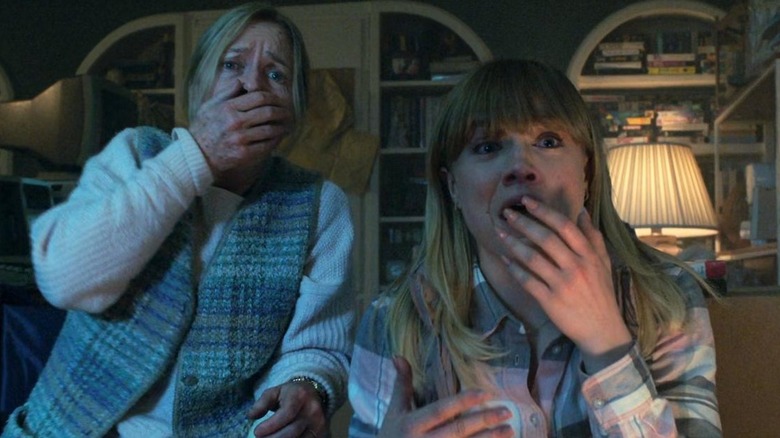 Susanna Thompson în rolul Jeanne și Maddie Hasson în rolul lui Sydney gâfâind la televizor în Malignant