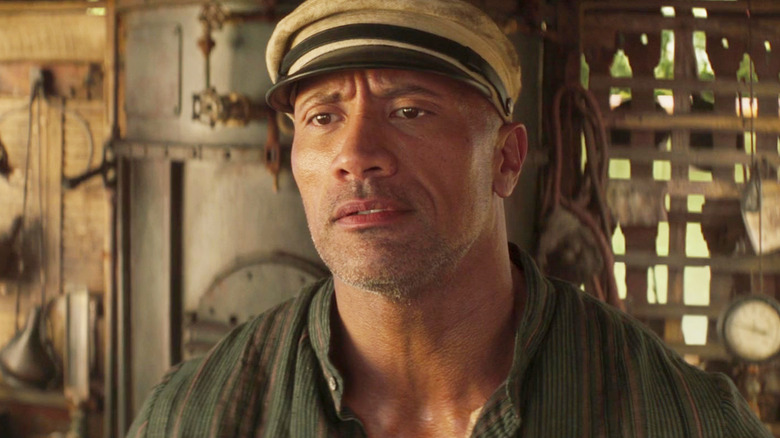 Dwayne Johnson în rolul lui Jack Wolff părând enervat în timp ce își poartă pălăria de căpitan în Jungle Cruise