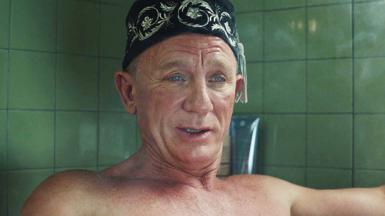 Daniel Craig ca Benoit Blanc purtând un fes într-o cadă în Glass Onion: A Knives Out Mystery