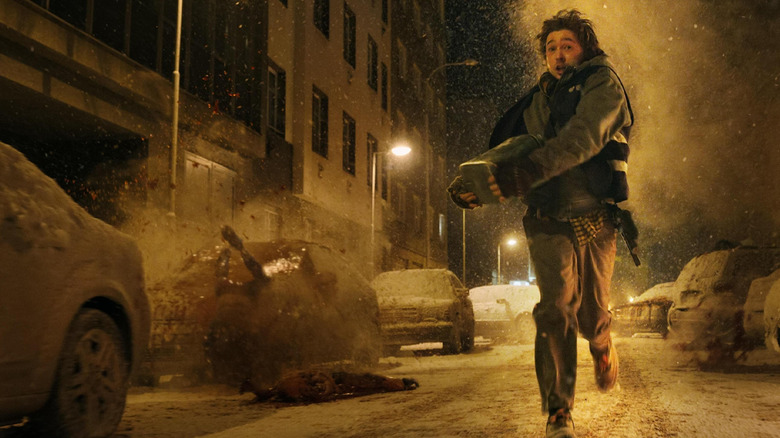 Austin Abrams ca Bryan alergând pe stradă în timp ce cadavrele explodează în jurul lui în Resident Evil (2026)