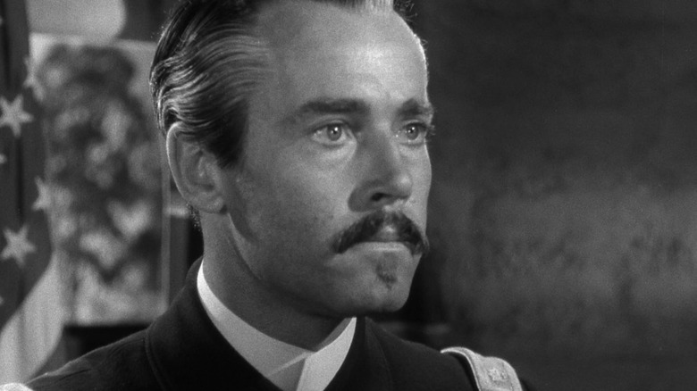 Owen Thursday, cu mustață și păr alunecat, arătând intenționat în Fort Apache