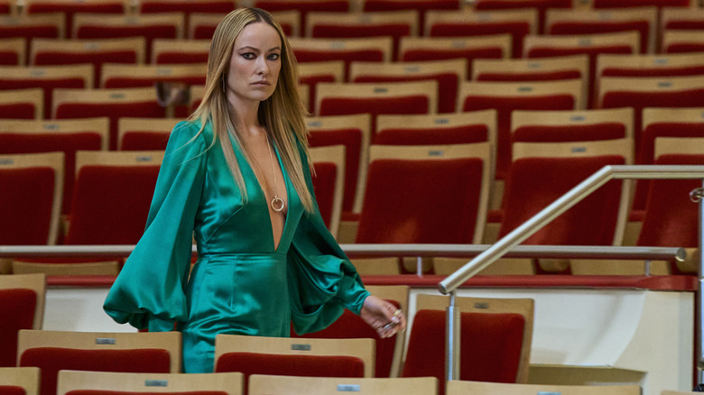 Olivia Wilde în rolul lui Carol Spedding purtând o rochie verde și mergând printr-un teatru gol din Behemoth!
