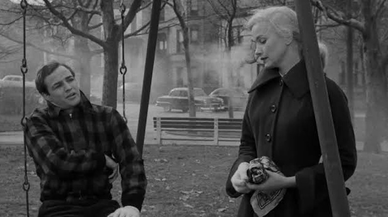 Marlon Brando în rolul lui Terry Malloy stă pe un leagăn și împarte un moment cu Eva Marie Saint în rolul lui Edie Doyle în On the Waterfront
