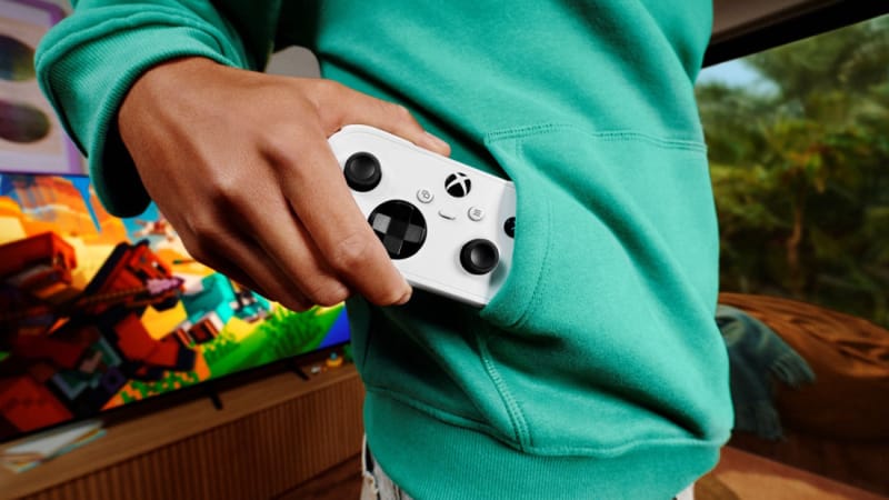 Controlerul Xbox Nano reduce jocul la dimensiunea de buzunar 2 Controlerul Xbox Nano ținut într-o mână lângă un smartphone pentru a-și arăta amprenta de buzunar