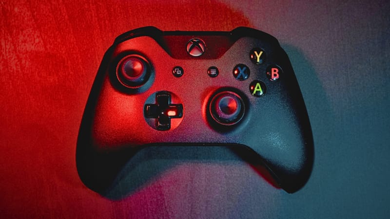 Sistemul de arme laser al Marinei SUA se declanșează acum cu un controler Xbox 1 Marinar ținând în mână un controler în stil Xbox folosit pentru a opera sistemul de arme laser al Marinei pe o navă